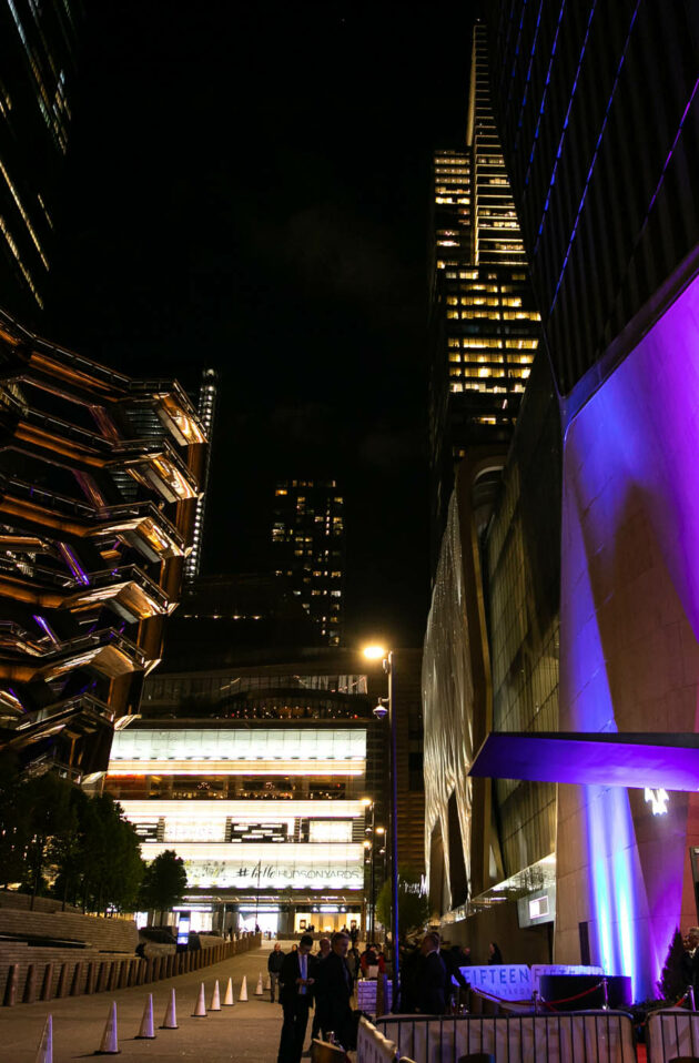 Evening view of a contemporary event venue space with illuminated architectural structures in an urban plaza.