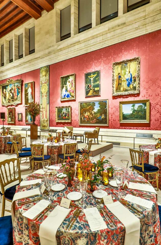 Elegant dining hall with tables set for a formal event, surrounded by ornate art and richly decorated walls, serving as an ideal event venue space.