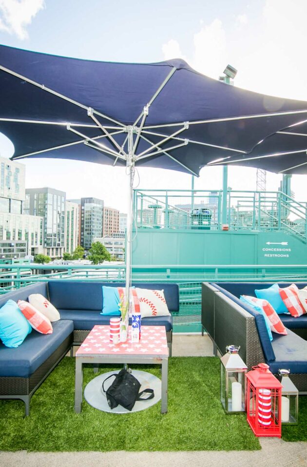 Outdoor lounge area with sofas and tables set up under canopy shades at a stadium managed by a top-tier event planning company.