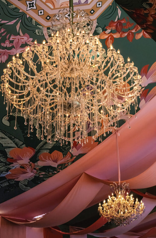 The exclusive amfAR Palm Beach Gala event seated gala dinner with stunning tent featuring custom fabric draped among crystal chandeliers. Event designed by  JWennes Events.