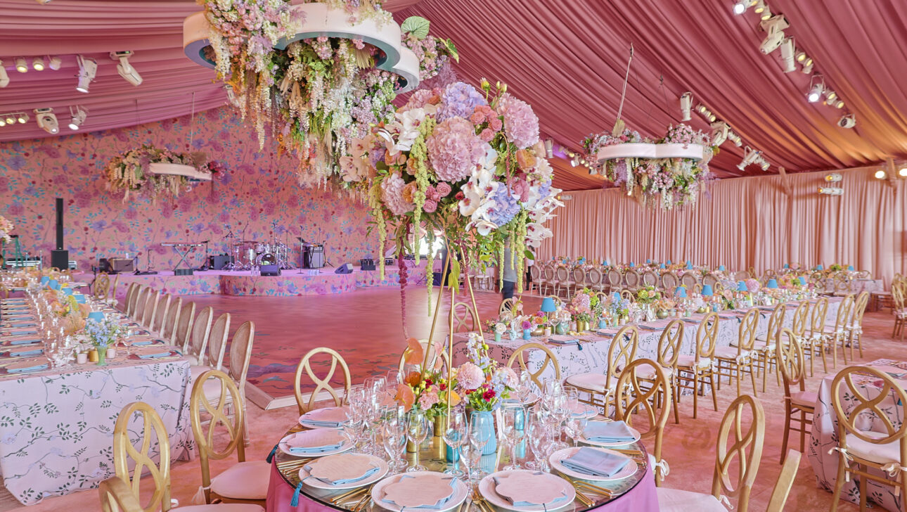 Extravagant wedding reception with draped pink tent ceilings and custom cascading floral chandelier. Designed by  JWennes Events.