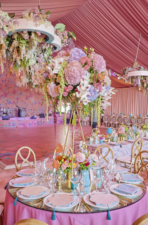 Extravagant wedding reception with draped pink tent ceilings and custom cascading floral chandelier. Designed by  JWennes Events.